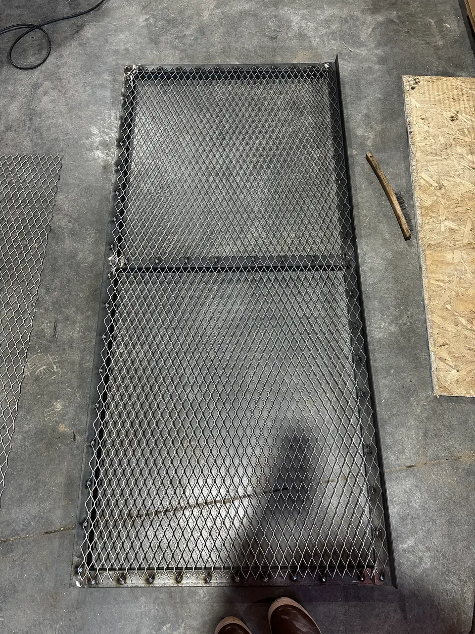 Expanded-metal cover with a welded steel frame before finishing